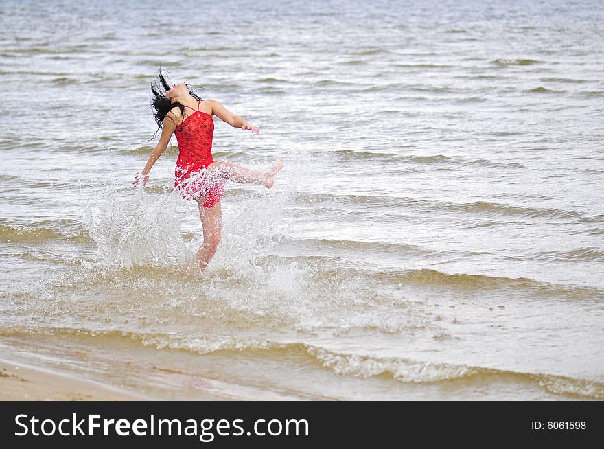 Beautiful happy woman dancing on the beach