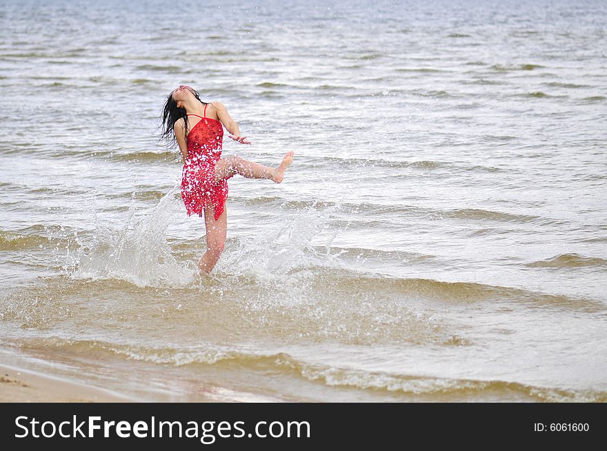 Beautiful happy woman dancing on the beach