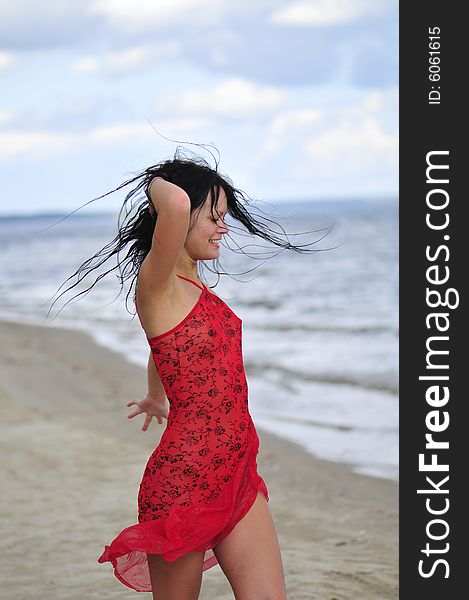 Beautiful happy woman dancing on the beach