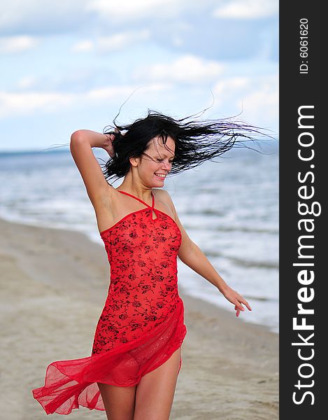 Beautiful happy woman dancing on the beach