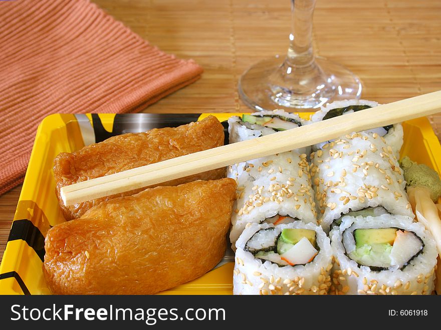 Assortment of Sushi and a Rice Roll with chop sticks. Assortment of Sushi and a Rice Roll with chop sticks