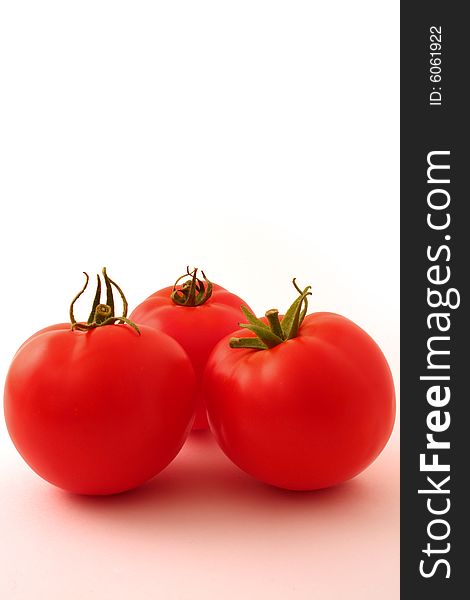 Group of three tomatoes set against a white backdrop. Group of three tomatoes set against a white backdrop