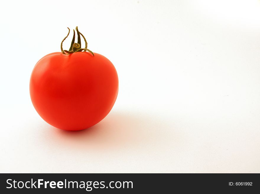 Single tomato set against a white backdrop. Single tomato set against a white backdrop
