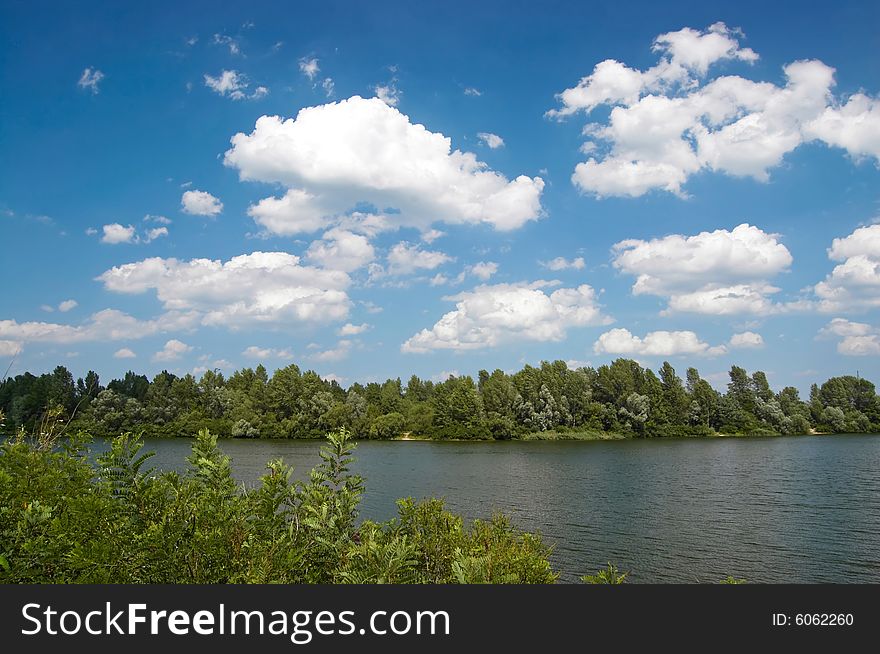 Summer landscape with trees, sky and river