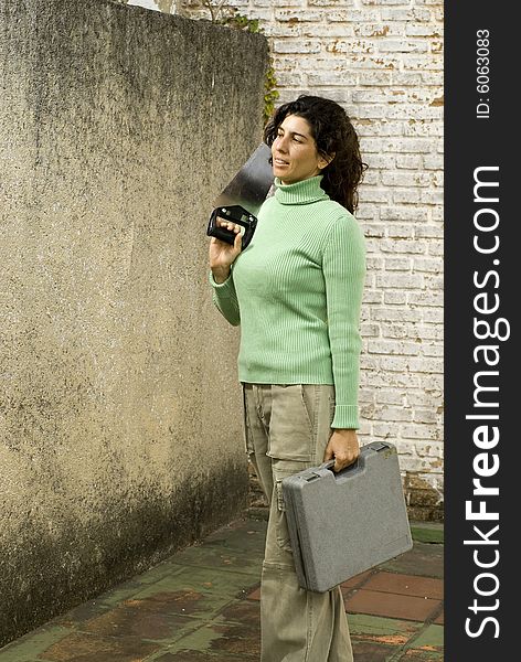 Woman stands while holding handsaw and toolkit. Vertically framed photo. Woman stands while holding handsaw and toolkit. Vertically framed photo.