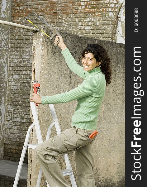 Smiling woman using tools. Vertically framed photo. Smiling woman using tools. Vertically framed photo.