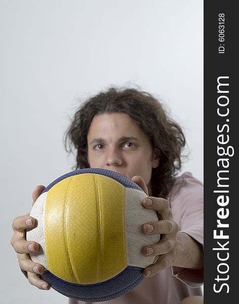 Man holding a volleyball out in front of him. Vertically framed photograph. Man holding a volleyball out in front of him. Vertically framed photograph