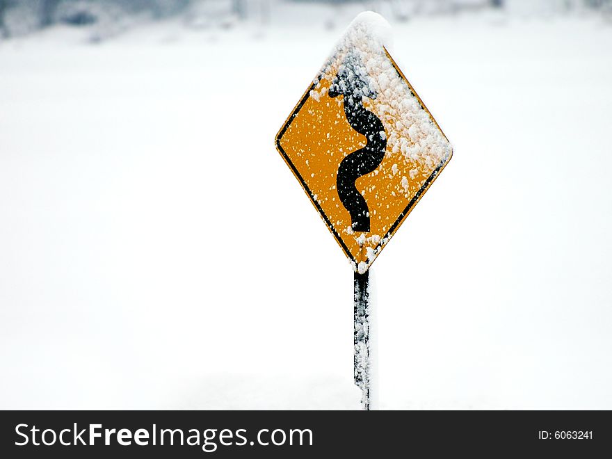 Windy road sign with snow on it. Horizontally framed photo. Windy road sign with snow on it. Horizontally framed photo.