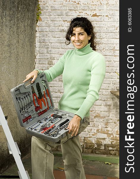 Smiling woman holding a tool kit. Vertically framed photo. Smiling woman holding a tool kit. Vertically framed photo.