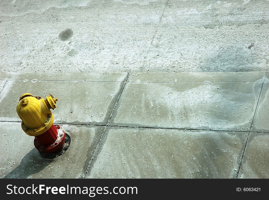 Red and yellow colored small fire hydrant on a side walk. Horizontally framed photo. Red and yellow colored small fire hydrant on a side walk. Horizontally framed photo.