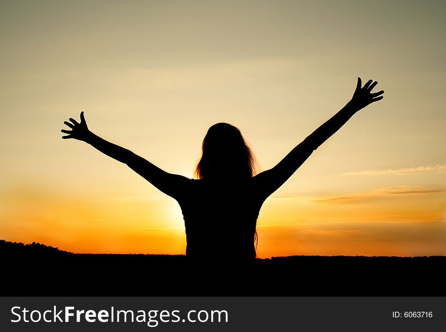 Dark silhouette of the pleased girl on a background of a decline. Dark silhouette of the pleased girl on a background of a decline