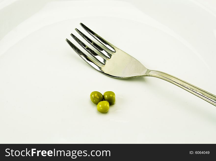 Three peas and a fork on a plate. Three peas and a fork on a plate