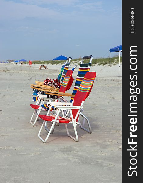 Multi-colored beach chairs on the sand in front of the dunes