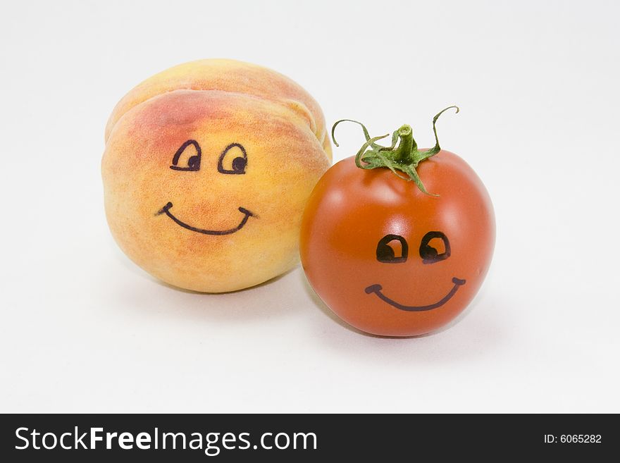 Animated peach and tomato on white background. Eyes and mouth drawn on each fruit and vegetable respectively. Animated peach and tomato on white background. Eyes and mouth drawn on each fruit and vegetable respectively.