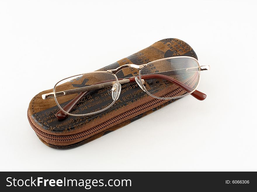 On a white background it is located about a brown case from suede, glasses from above lay. On a white background it is located about a brown case from suede, glasses from above lay