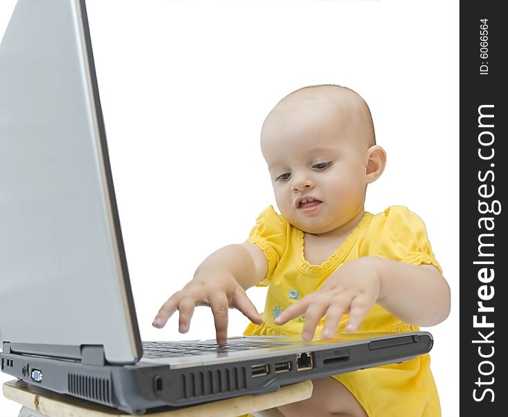 Little baby girl in yellow playing with laptop. Little baby girl in yellow playing with laptop