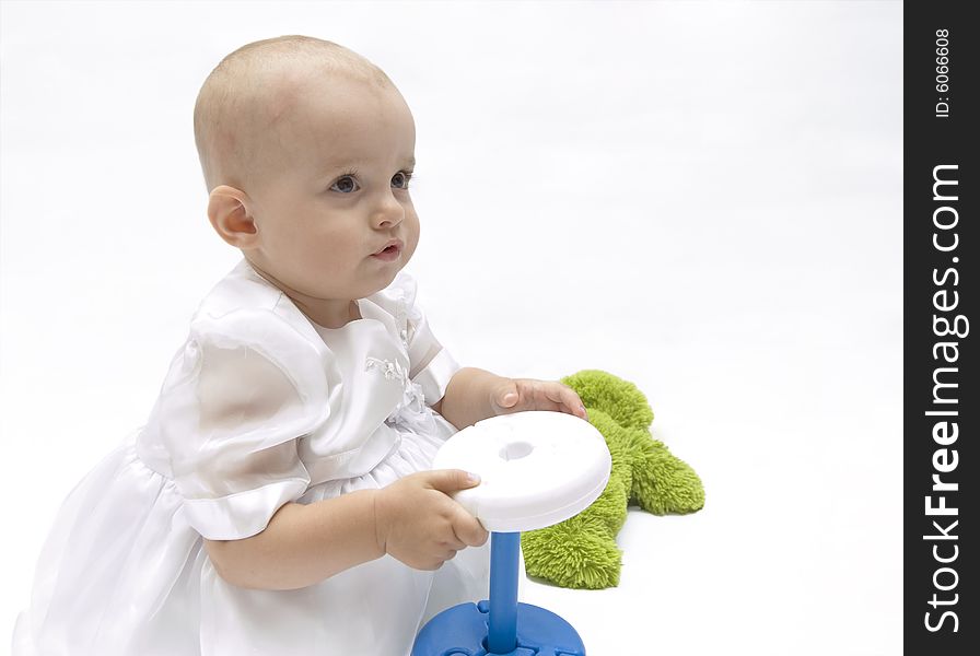 Little baby girl in white dress, playing with her toys. Little baby girl in white dress, playing with her toys