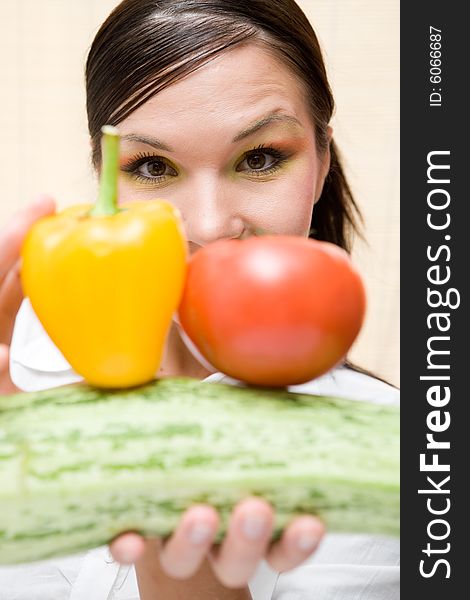 Attractive brunette woman holding vegetable. Attractive brunette woman holding vegetable