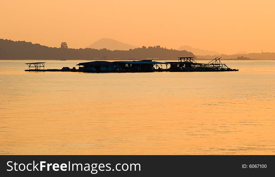 A tropical fish farm at sea as seen in the glow of dawn