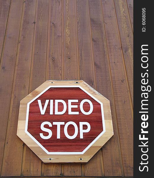 Red video stop sign on a brown wood wall