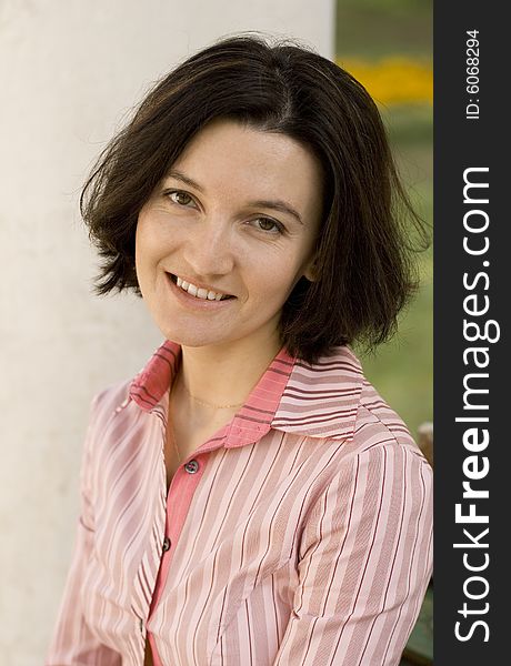 Outdoor portrait of smiling brunet woman