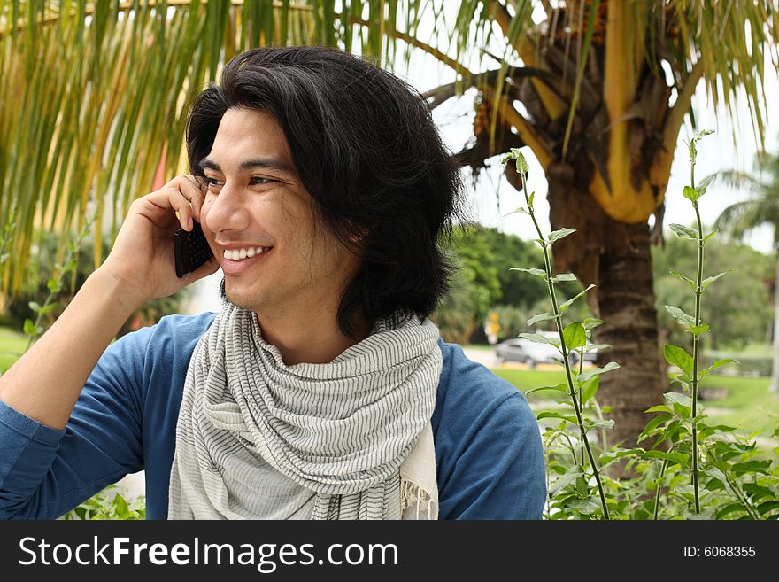 Young college student talking on a cell phone and smiling. Young college student talking on a cell phone and smiling.