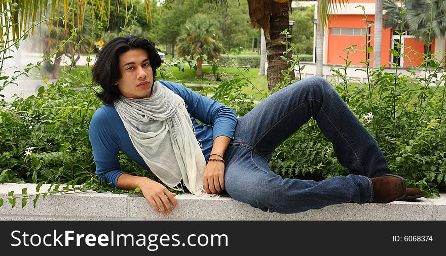 Man sitting on a concrete ledge. Man sitting on a concrete ledge