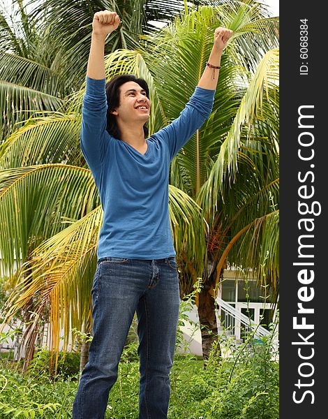 Young man raising his arms in the air as a victorious gesture. Young man raising his arms in the air as a victorious gesture