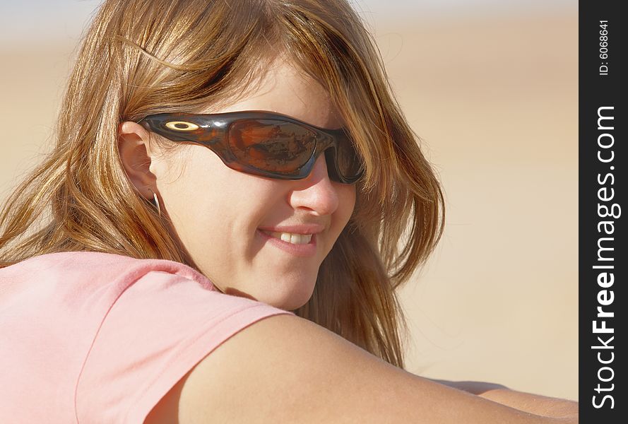 Young girl with sunglasses that reflect family activity in glasses smiles happy while looking. Young girl with sunglasses that reflect family activity in glasses smiles happy while looking