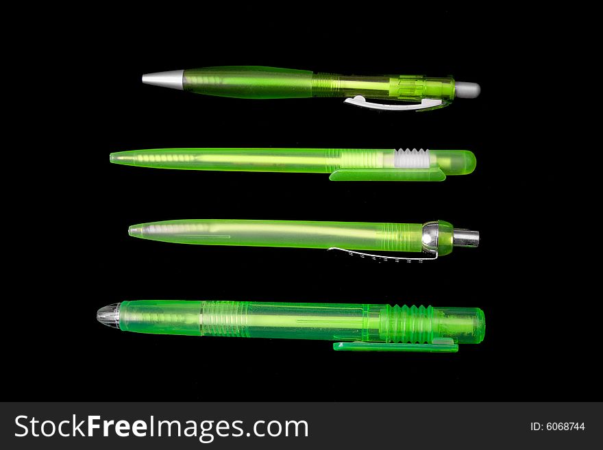 Green pens on black ground