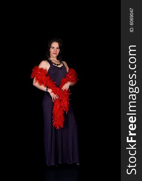 Glamorous young lady with purple dress and red boa on black background, studio shot