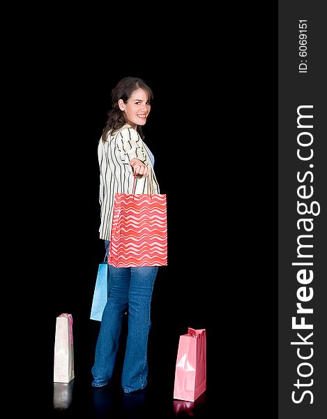 Happy young woman with shopping bags, black background, studio shot. Happy young woman with shopping bags, black background, studio shot