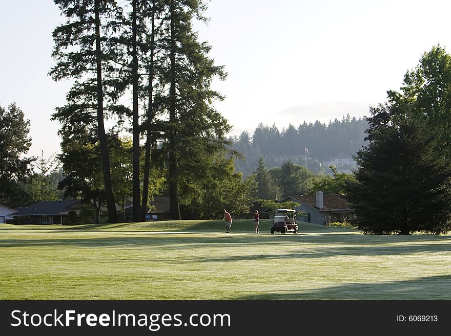 Far off shot of couple playing golf. Horizontally framed photo. Far off shot of couple playing golf. Horizontally framed photo