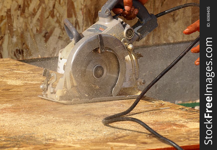 Person using a power saw. Horizontally framed photo. Person using a power saw. Horizontally framed photo.