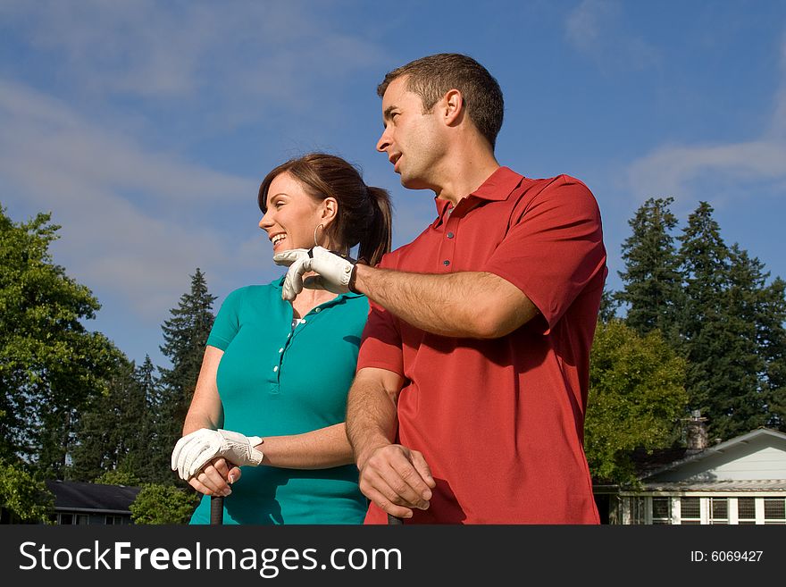 Golfers stand in front of camera. Man is pointing into the distance. Horizontally framed photo. Golfers stand in front of camera. Man is pointing into the distance. Horizontally framed photo.