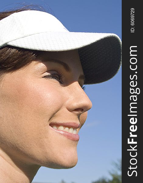 Close up of female golfer's profile. She is smiling. Vertically framed photo. Close up of female golfer's profile. She is smiling. Vertically framed photo.