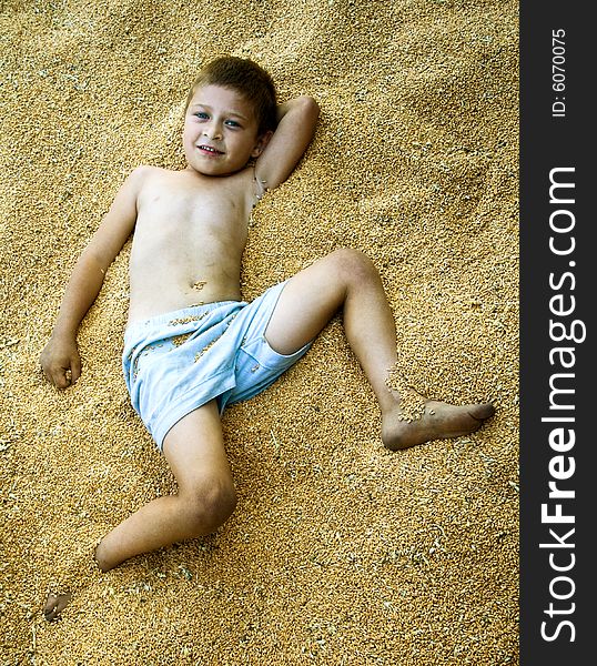 Portrait of cute kid laying in corn seeds. Portrait of cute kid laying in corn seeds