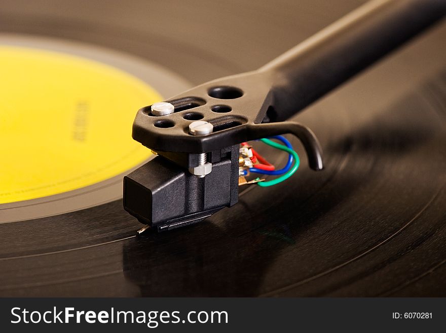 Close-up image of a turntable showing details of the cartridge and tonearm