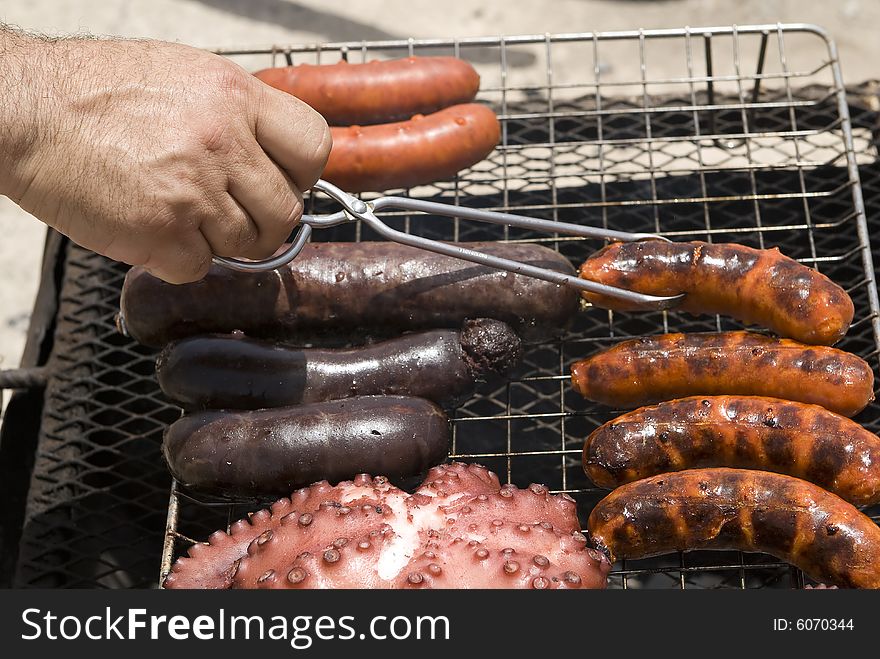 Hand Hold A Bratwurst On The Barbecue