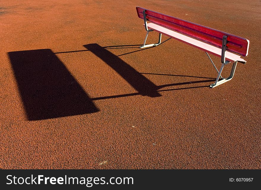 A red sports bench on red rubber track. A red sports bench on red rubber track