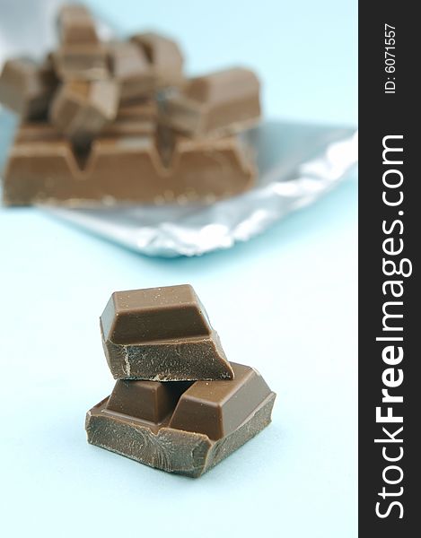 Milk chocolate isolated against a blue background