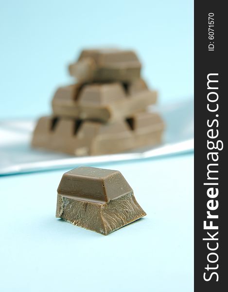 Milk chocolate isolated against a blue background