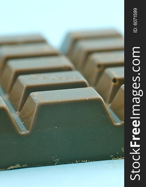 Milk chocolate isolated against a blue background