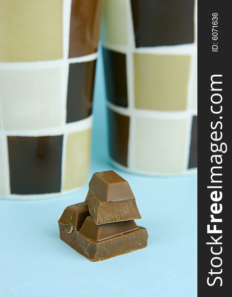 Milk chocolate isolated against a blue background. Milk chocolate isolated against a blue background