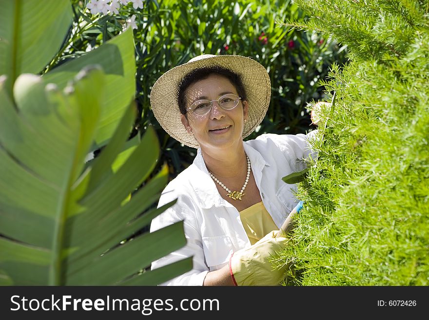 Portrait of senior Italian woman gardening, looking at camera