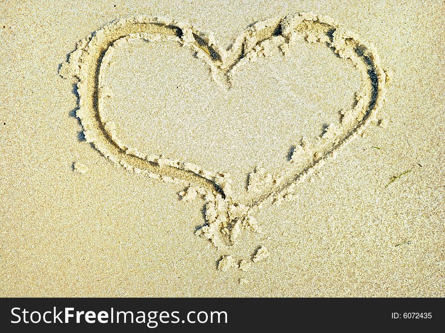 Hearts drawn on sand on sea beach