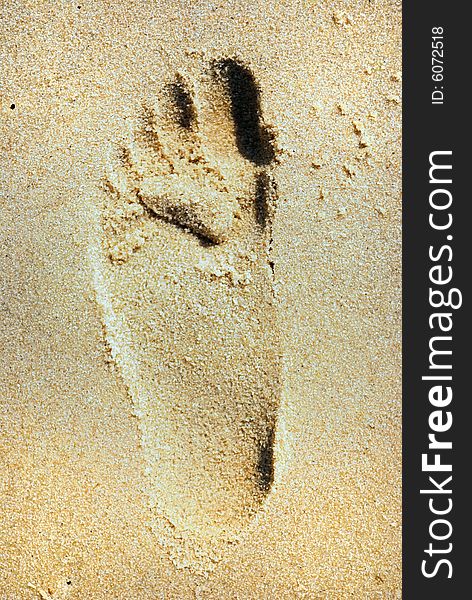 Foots drawn on sand on sea beach