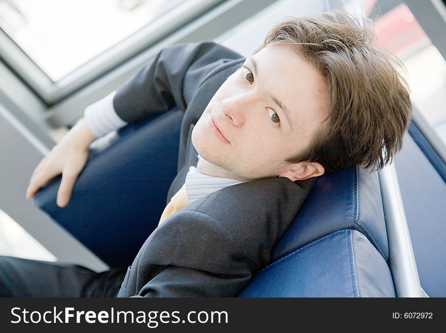 Young businessman taking a nap sitting in an armchair. Young businessman taking a nap sitting in an armchair
