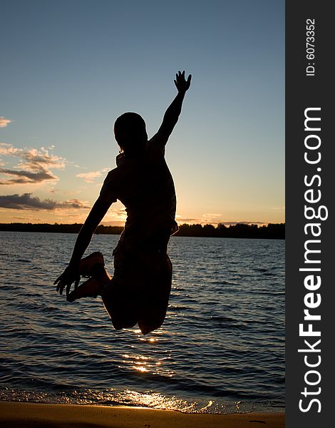 Young man jump over sunlight near the river