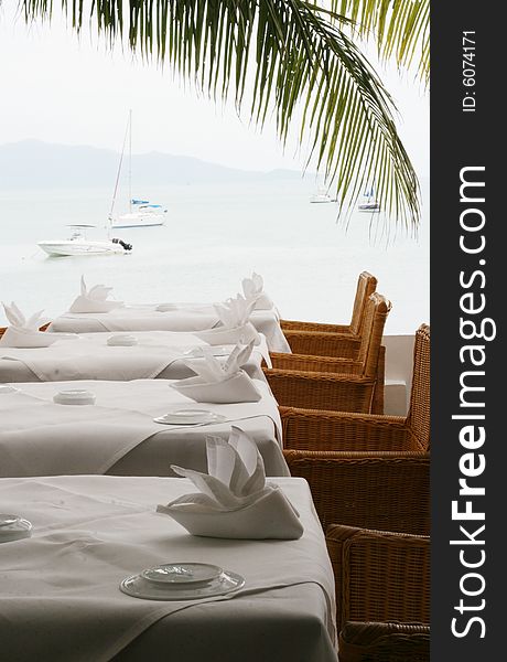 Elegant white table setting overlooking the ocean.